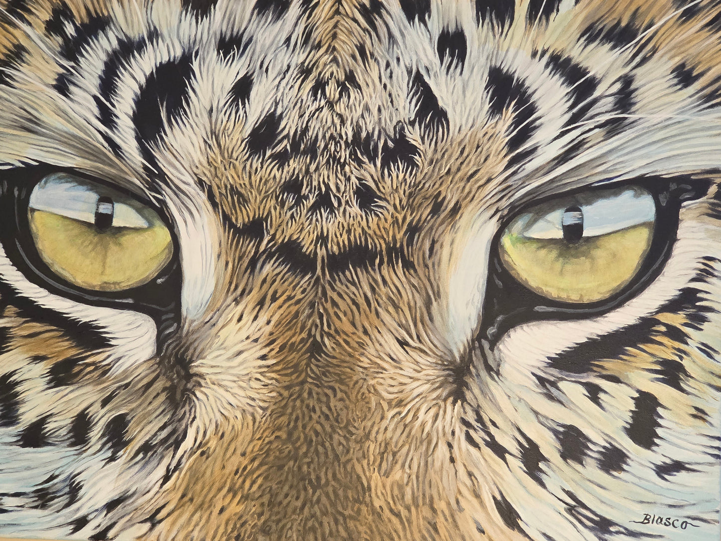Close-up of a leopard's face with detailed fur and yellow eyes.