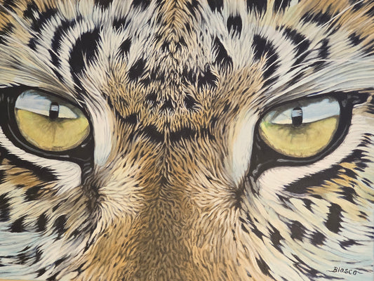 Close-up of a leopard's face with detailed fur and yellow eyes.